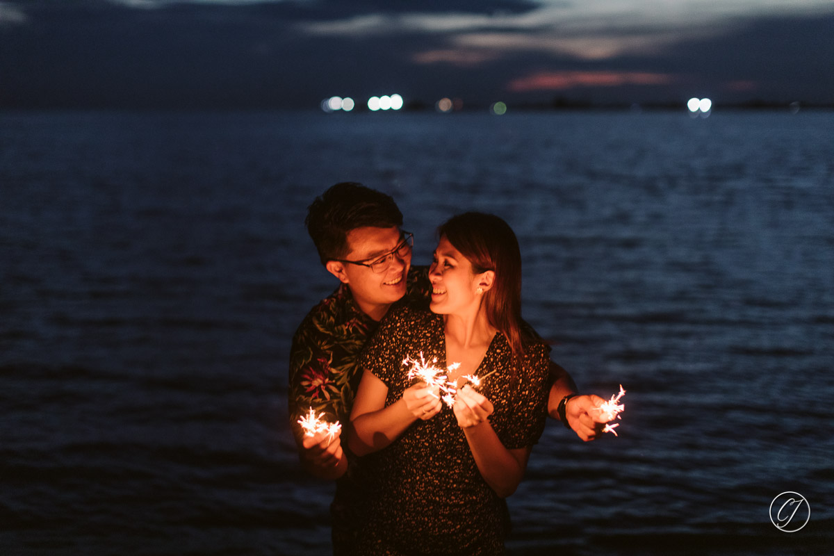 Couple with sparklers by the beach
