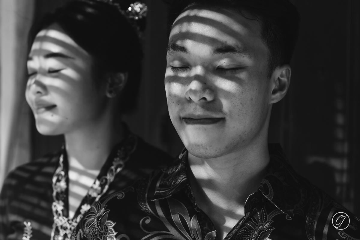 Traditional wooden Venetian blinds casting the shadow on couple