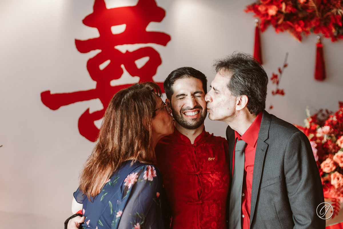 The Iranian groom and parents with Chinese wedding backdrop